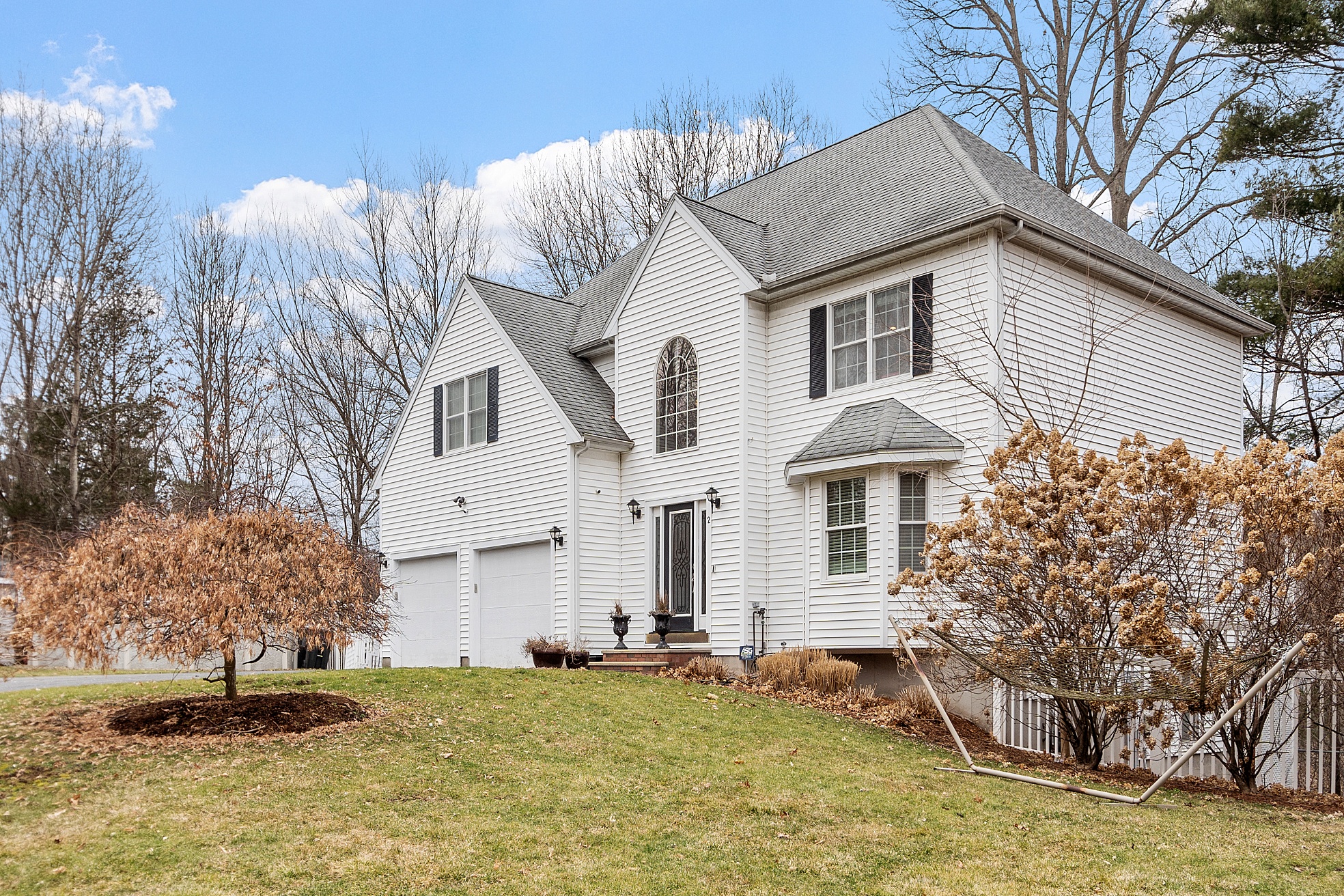White Colonial-style home with black shutters and a two-car garage in Wilmington, Massachusetts